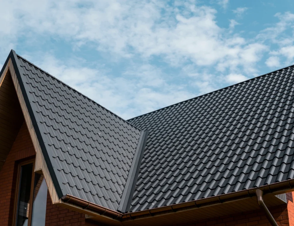 A modern house with a steeply pointed roof covered in UPVC tiles.